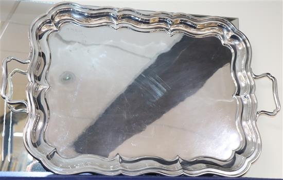 A George V silver shaped rectangular two handled tea tray, marks rubbed, Birmingham, 1930?, 92 oz.